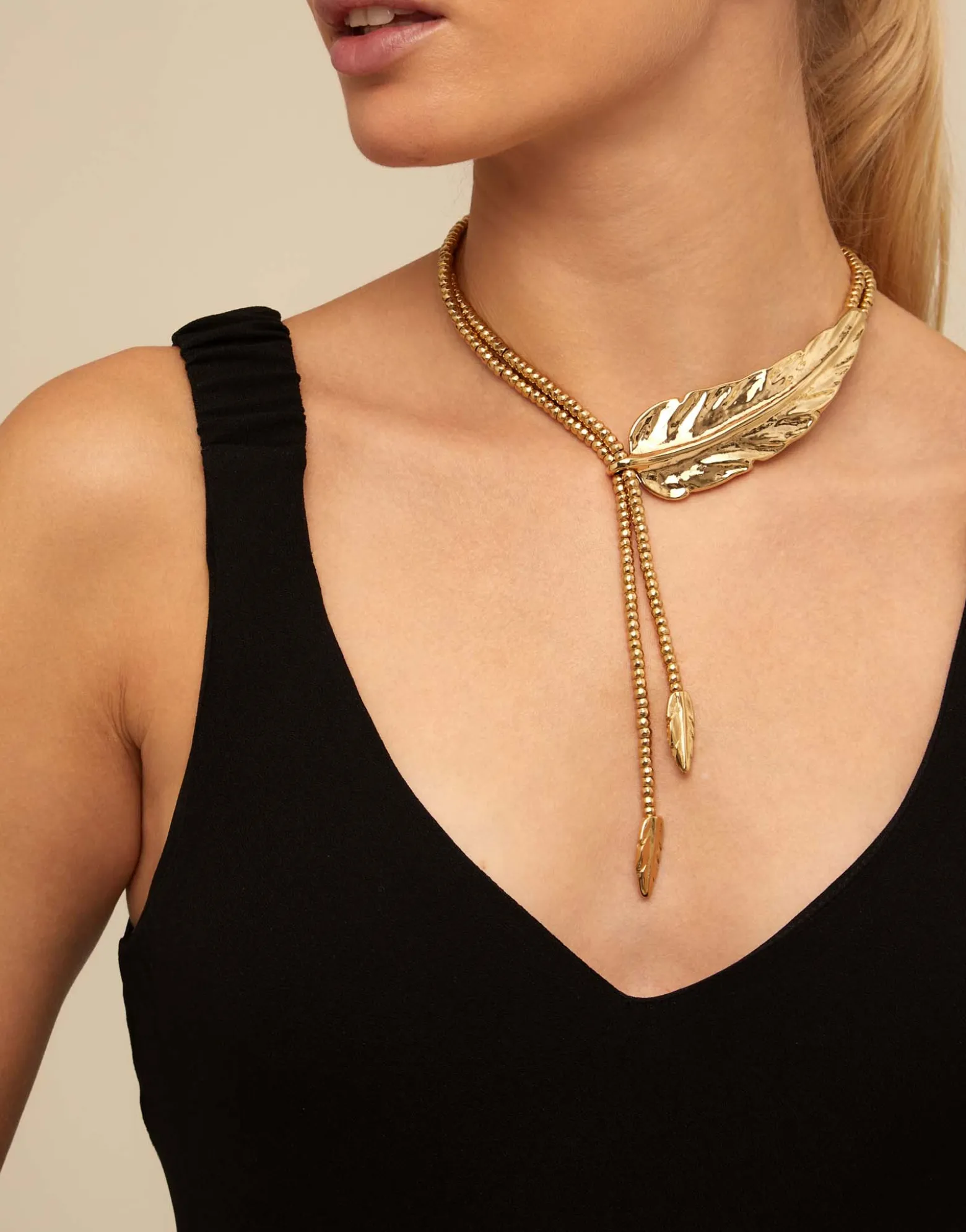 Collar largo bañado en oro de 18k rematado en pequeñas plumas