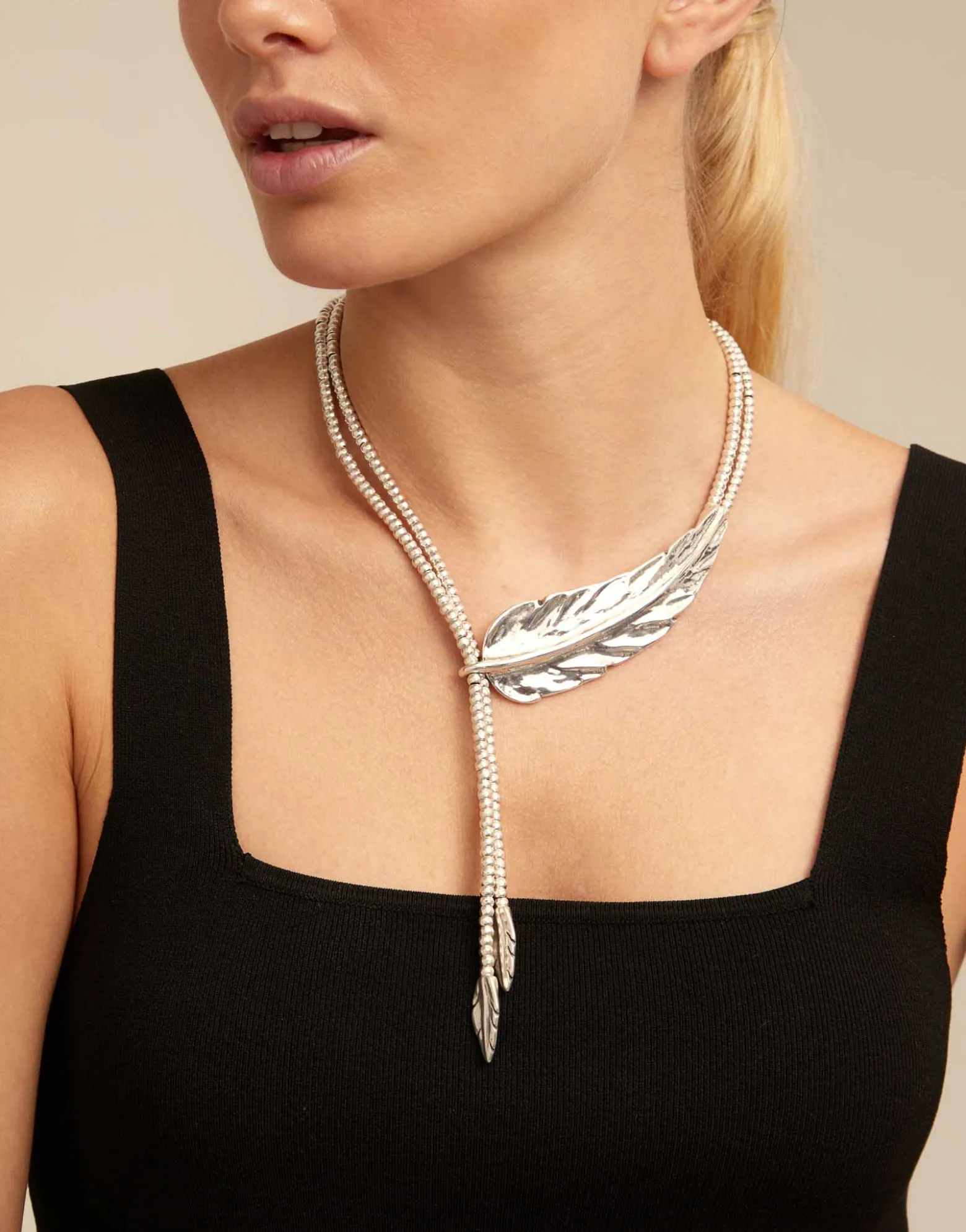Collar largo bañado en plata de ley rematado en pequeñas plumas