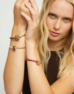 Pulsera combinada en cuero crema y oro 18k con adorno de mariposa