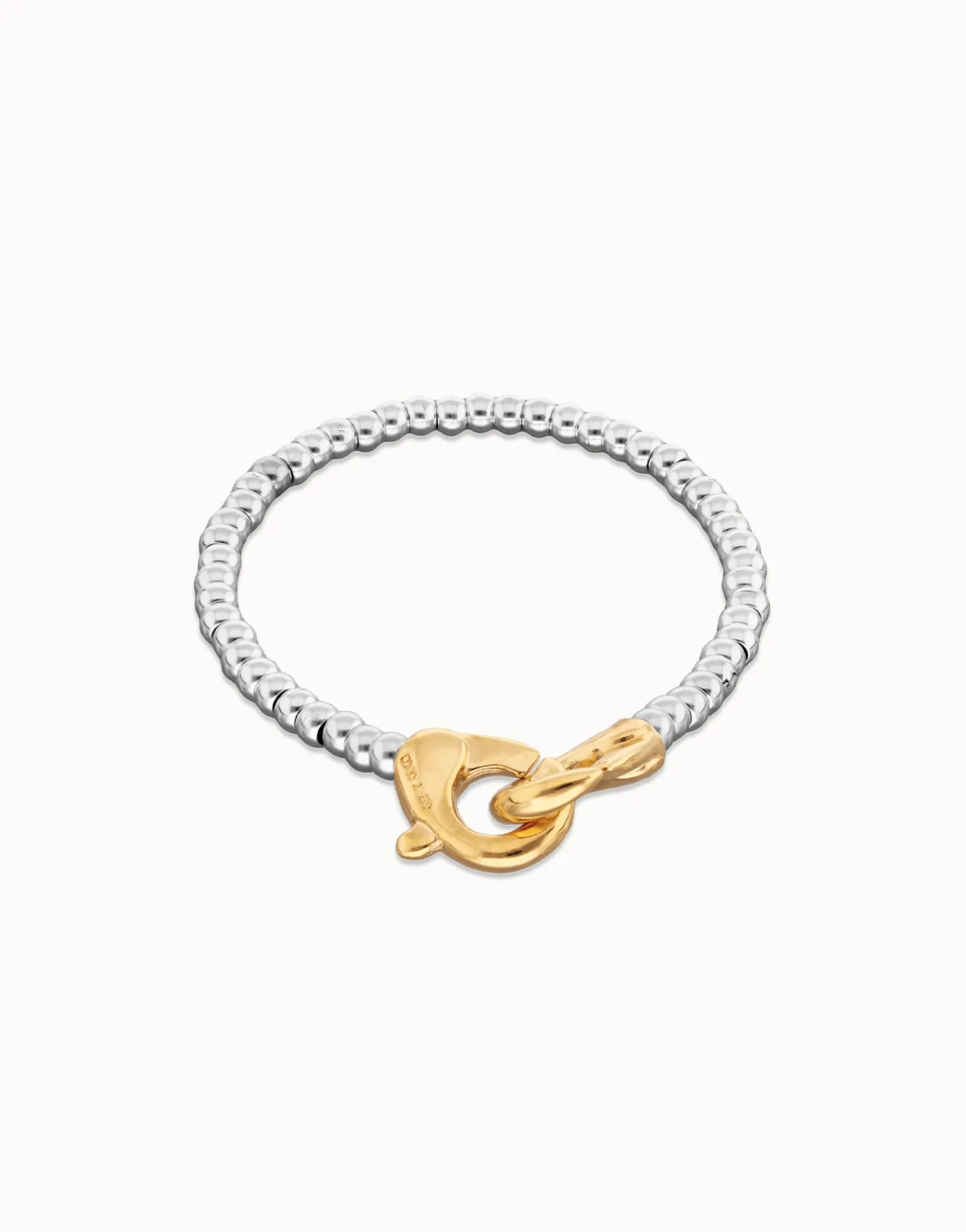 Pulsera de bolas pequeñas bañada en oro con mosqueton entrelazado en oro