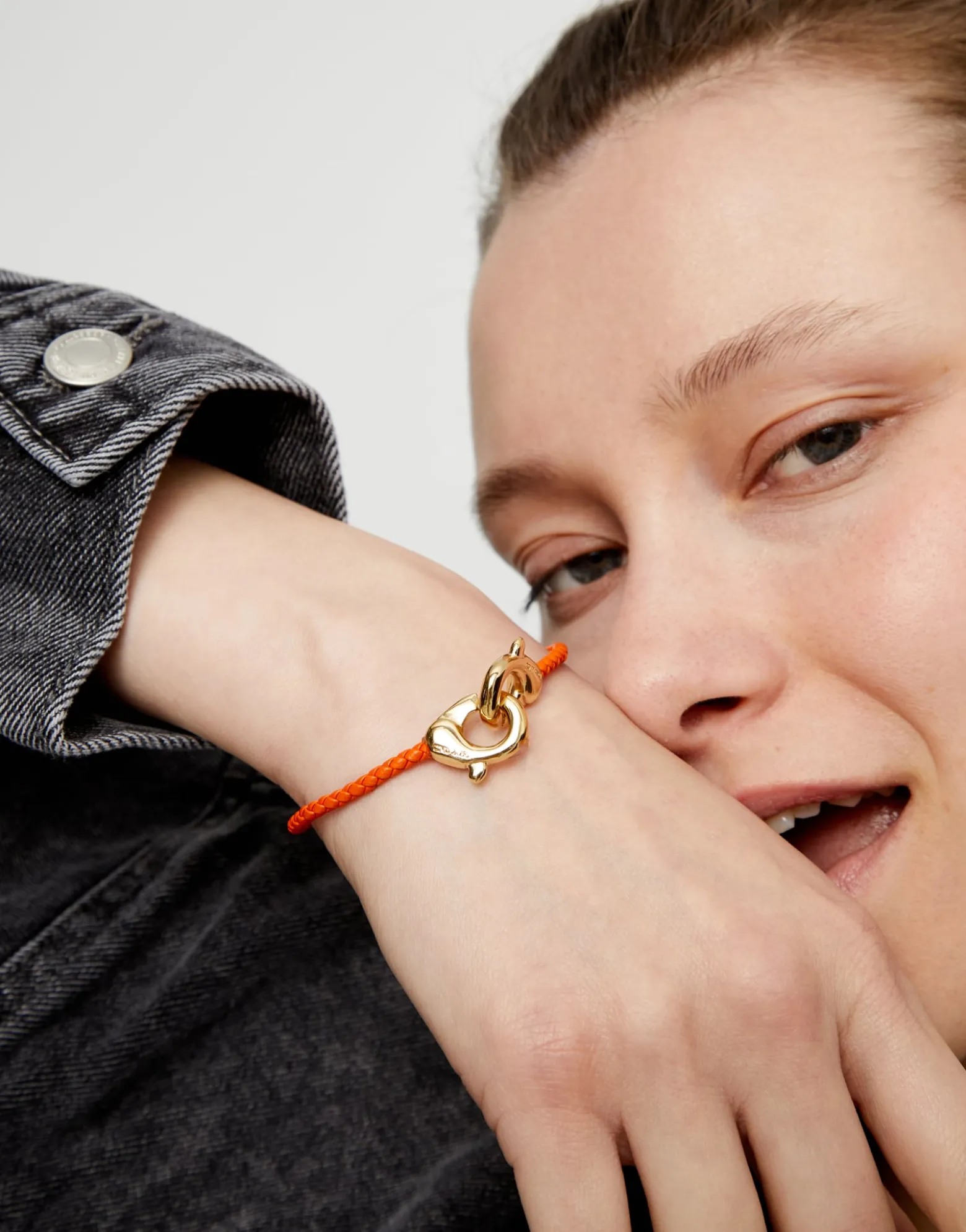 Pulsera de cuero naranja con mosquetón entrelazado en oro