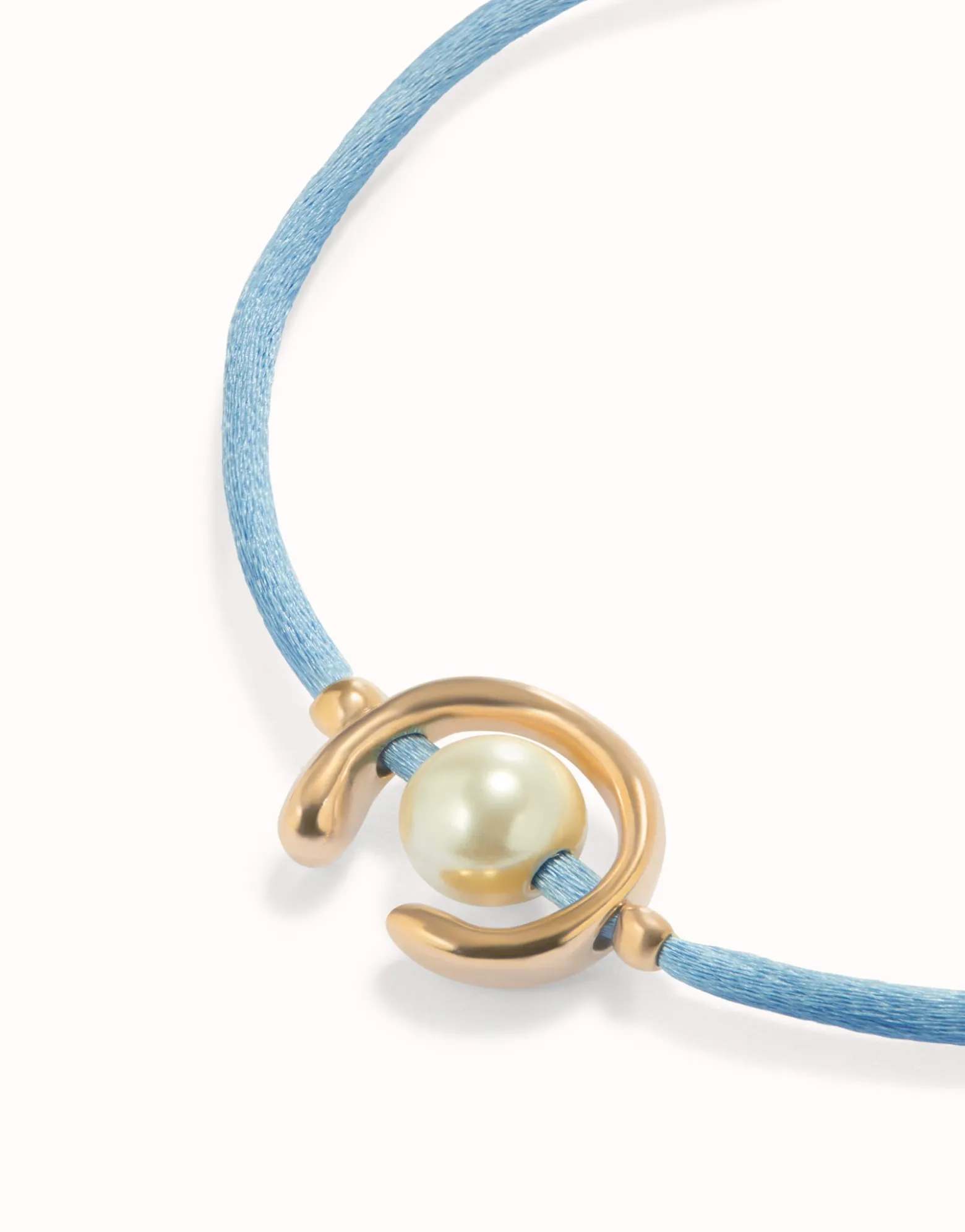 Pulsera de hilo azul con perla shell fornitura bañada en oro 18k.