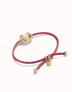 Pulsera de hilo malva con perla shell fornitura bañada en oro 18k.