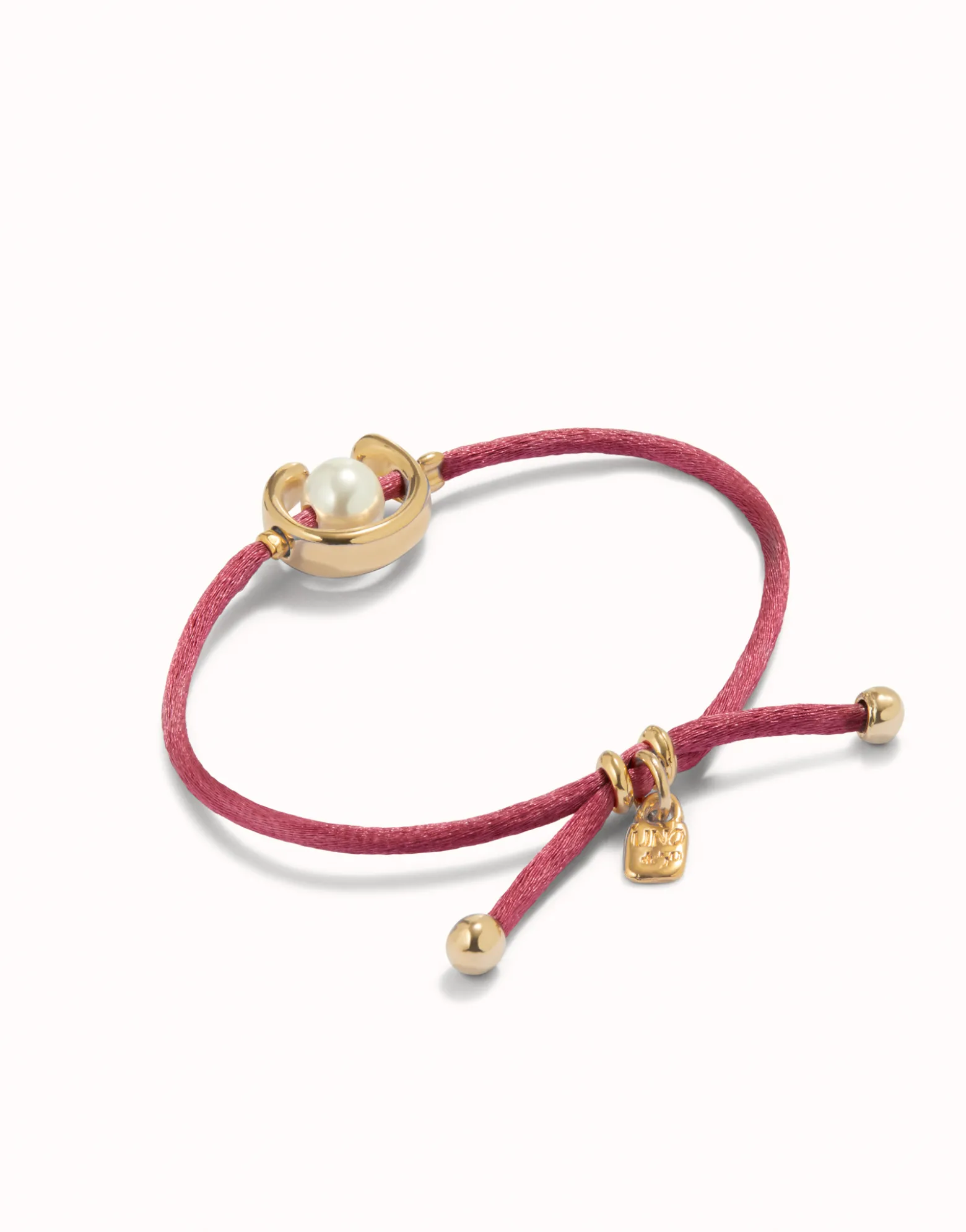 Pulsera de hilo malva con perla shell fornitura bañada en oro 18k.