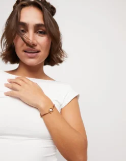 Pulsera de hilo marrón con perla shell fornitura bañada en oro 18k.