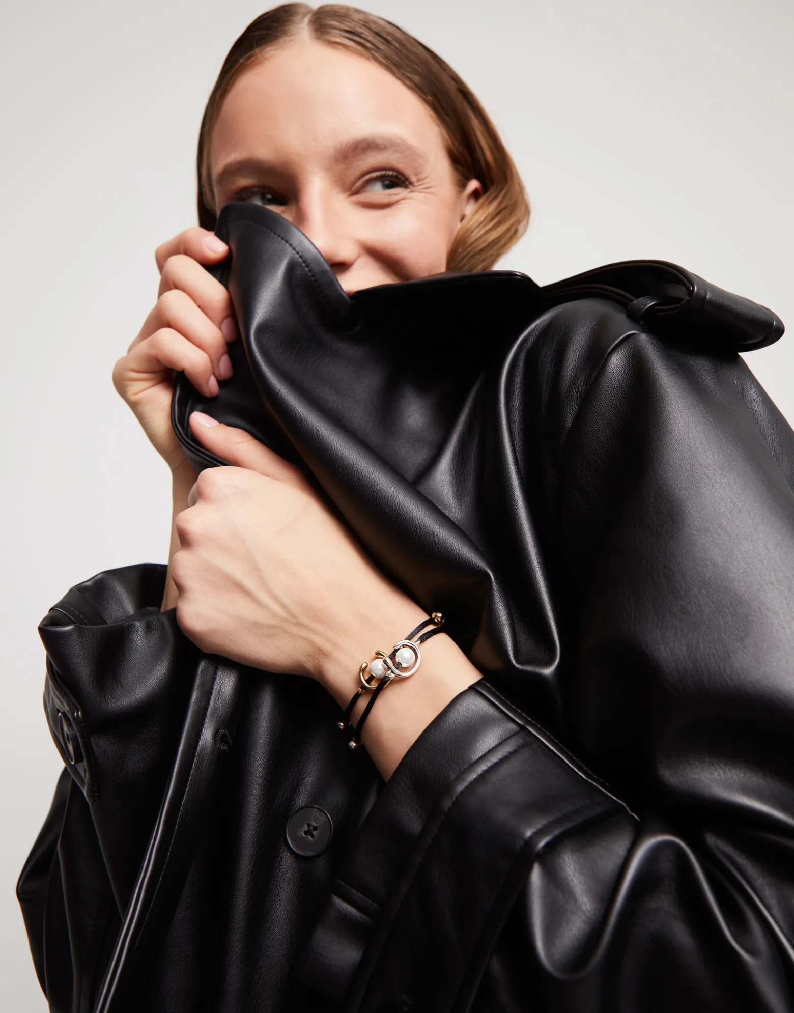 Pulsera de hilo negro con perla shell fornitura bañada en oro 18k.