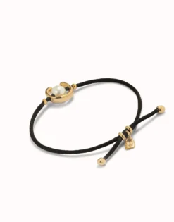 Pulsera de hilo negro con perla shell fornitura bañada en oro 18k.