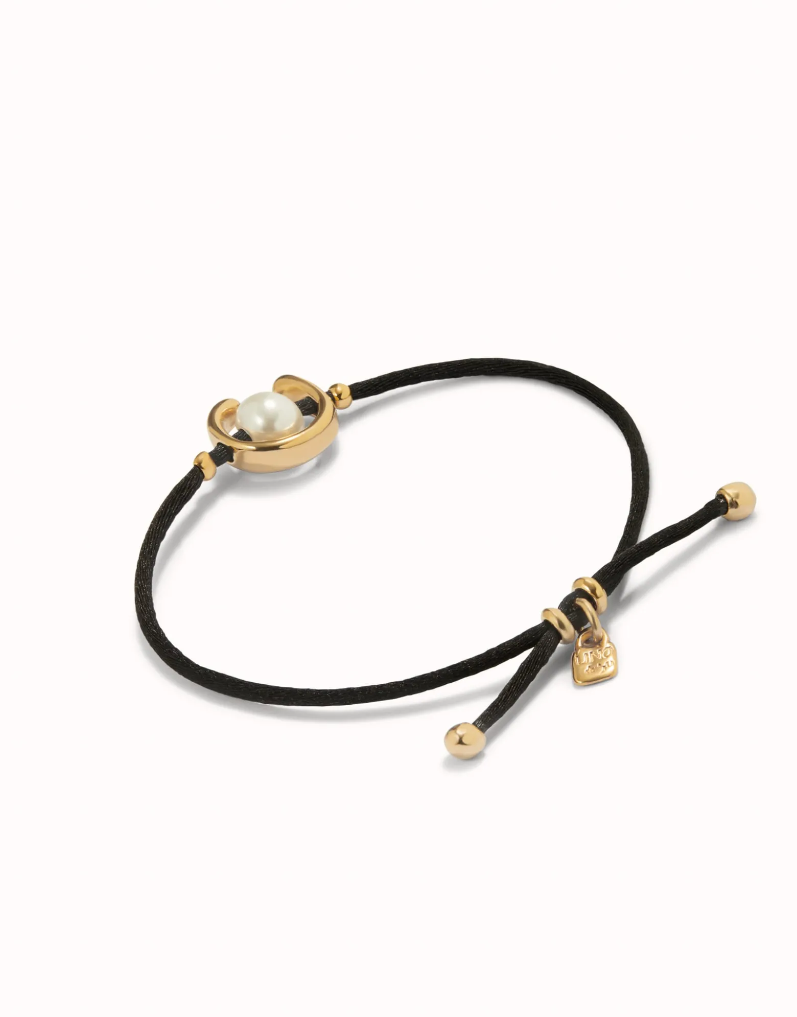 Pulsera de hilo negro con perla shell fornitura bañada en oro 18k.