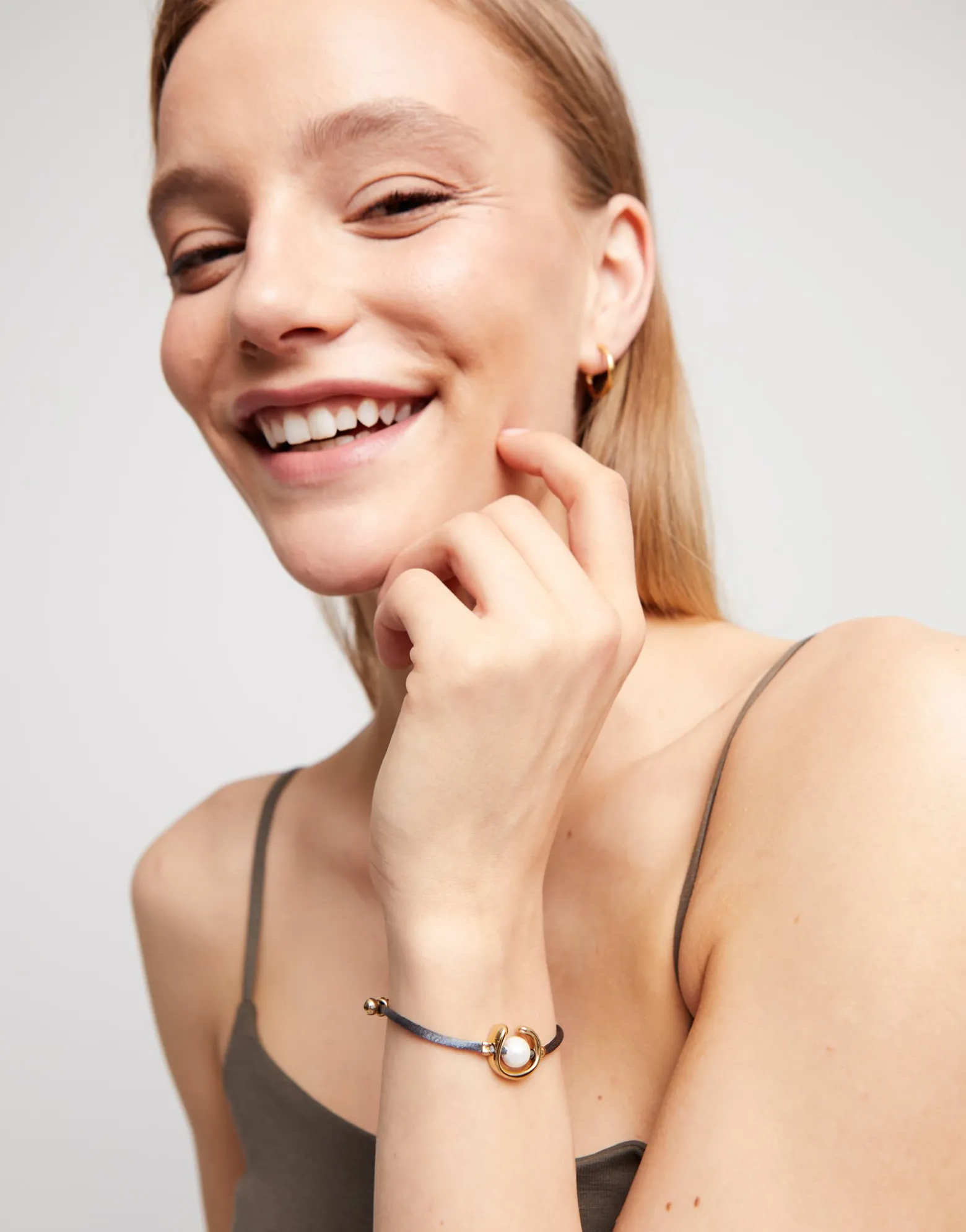 Pulsera de hilo negroso con perla shell fornitura bañada en oro 18k.