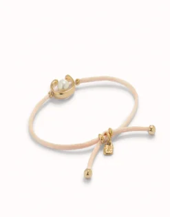 Pulsera de hilo salmón con perla shell fornitura bañada en oro 18k.