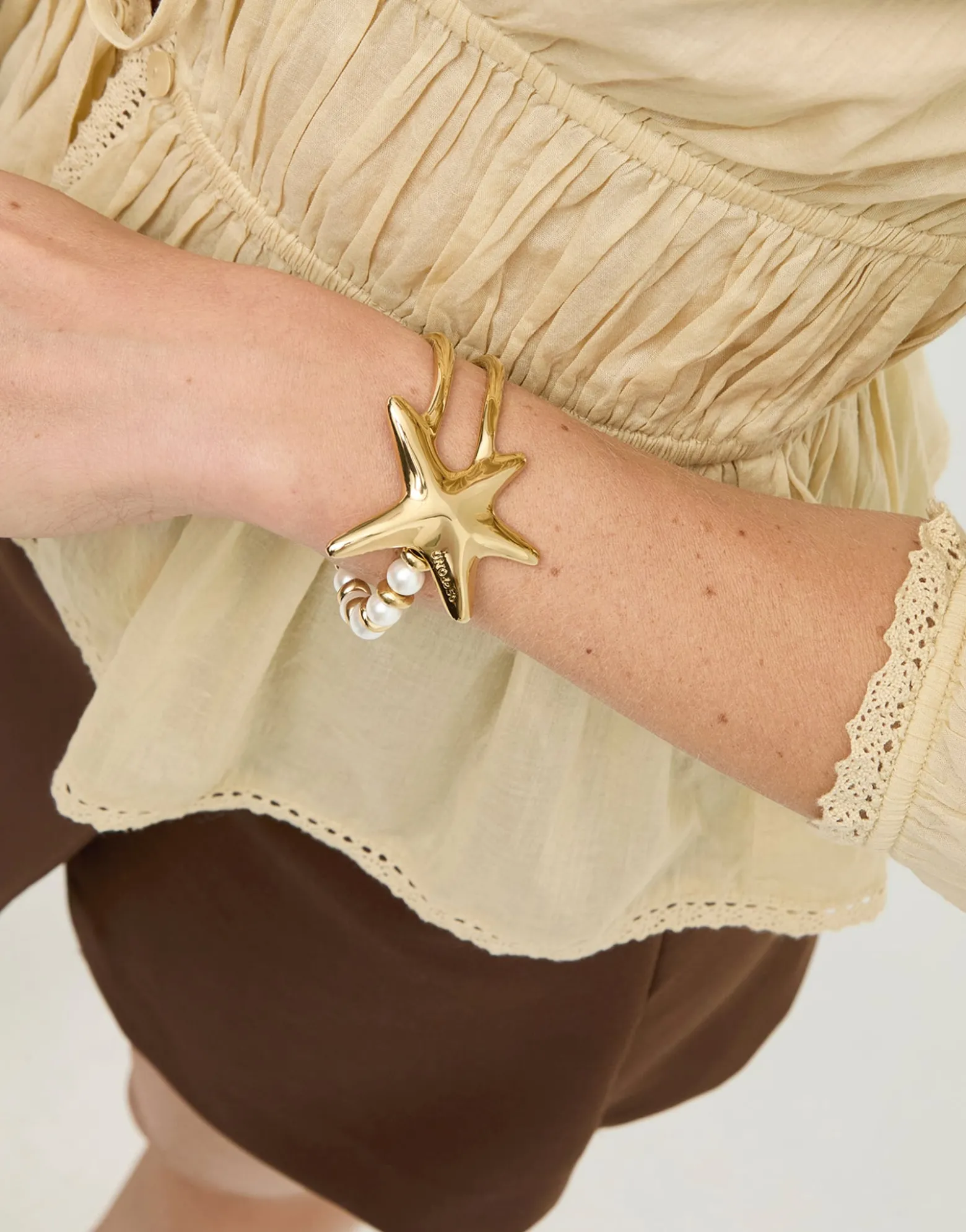 Pulsera semirrígida bañada en oro con perlas y estrella de mar
