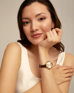 Reloj bañado en oro 18k con correa de cuero negra, esfera redonda con interior en color blanco